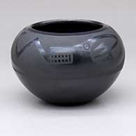 A black-on-black bowl decorated with an avanyu and geometric design
 by Marvin and Frances Martinez of San Ildefonso