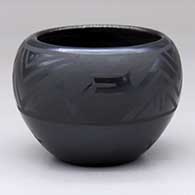 A black-on-black bowl decorated with an avanyu and geometric design
 by Marvin and Frances Martinez of San Ildefonso