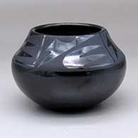 A black on black jar decorated with a four-panel geometric design above the shoulder
 by Maria Martinez of San Ildefonso