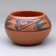 A small black on red bowl decorated with a four-panel geometric design above the shoulder
 by Johnny Cruz of San Ildefonso