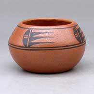 A small black on red bowl decorated with a four-panel geometric design above the shoulder
 by Johnny Cruz of San Ildefonso