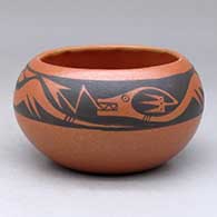 A small black on red bowl decorated with an avanyu and cloud formation geometric design
 by Johnny Cruz of San Ildefonso