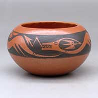 A black on red bowl decorated with an avanyu, rain cloud and geometric design
 by Johnny Cruz of San Ildefonso