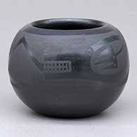 A small black on black jar decorated with an avanyu and geometric design
 by Marvin and Frances Martinez of San Ildefonso