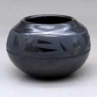 A black on black bowl decorated with a four-panel bat wing and geometric design above the shoulder
 by Santana Martinez of San Ildefonso