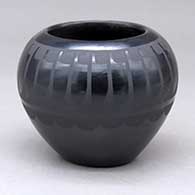 A black on black bowl decorated with a ring of feathers and geometric design
 by Santana Martinez of San Ildefonso