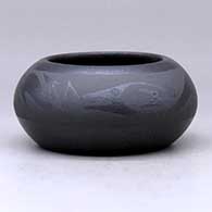 A micaceous black on black bowl decorated with an avanyu and cloud formation design around the shoulder
 by Johnny Cruz of San Ildefonso