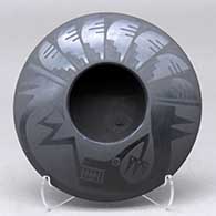 A black on black bowl decorated with an avanyu and feather design above the shoulder
 by Marvin and Frances Martinez of San Ildefonso
