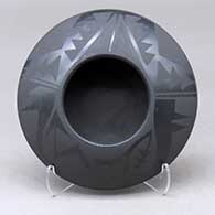 A black on black bowl decorated with an avanyu and geometric design above the shoulder
 by Marvin and Frances Martinez of San Ildefonso