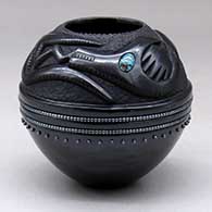 A matte and polished black jar decorated with a carved avanyu with inlaid stones and strings of inlaid heishi beads and single inlaid heishi beads
 by Russell Sanchez of San Ildefonso
