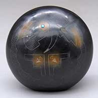 A black seed pot with sienna spots and decorated with a sgraffito stylized avanyu and geometric design plus an inlaid stone
 by Barbara Gonzales of San Ildefonso
