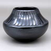 A black on black jar decorated with a band of feathers design around the recurved neck
 by Maria Martinez of San Ildefonso