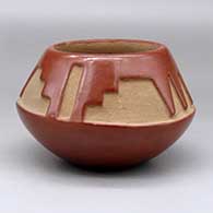 A red bowl carved with a four panel kiva step and geometric design above the shoulder
 by Rosalie Aguilar of San Ildefonso