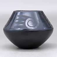 A black on black jar decorated above the shoulder with a four-panel bat wing, spiral and geometric design, click or tap to see a larger version