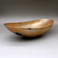 A large, oval golden micaceous serving bowl with fire clouds
 by Angie Yazzie of Taos