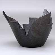A stylized micaceous black prayer bowl, click or tap to see a larger version