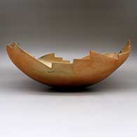 An oval golden micaceous bowl with a kiva step carved rim and fire clouds
 by Angie Yazzie of Taos