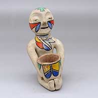 A polychrome Tesuque Rain God with a pot in his lap
 by Unknown of Tesuque