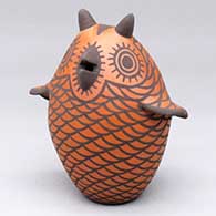 A red-on-black owl figure decorated with a bird element and geometric design
 by Carlos Laate of Zuni