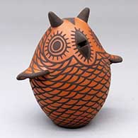 A red-on-black owl figure decorated with a bird element and geometric design
 by Carlos Laate of Zuni