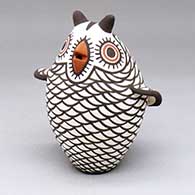 A polychrome owl figure decorated with a bird element and geometric design
 by Carlos Laate of Zuni