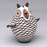 A polychrome owl figure decorated with a bird element and geometric design
 by Carlos Laate of Zuni