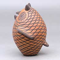 A black on red owl figure decorated with bird element appliques and design, click or tap to see a larger version