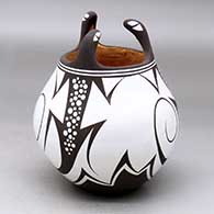 A polychrome jar decorated with three lizard head appliques and a lizard and geometric design
 by Anderson Jamie Peynetsa of Zuni