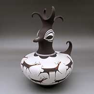 A polychrome duck effigy pot with a feathered crown and decorated around the body with a deer-with-heart-line and geometric design
 by Anderson Peynetsa of Zuni