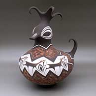 Click for a larger view A polychrome duck effigy pot with a feathered crown and decorated with a deer-with-heart-line and geometric design
by Anderson Peynetsa of Zuni