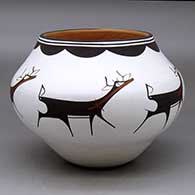 A polychrome jar decorated around the body with a deer with heart line and geometric design
 by Anderson Peynetsa of Zuni