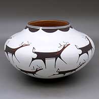 A polychrome jar decorated around the body with a deer with heart line and geometric design
 by Anderson Peynetsa of Zuni