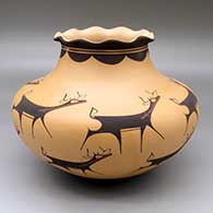 A polychrome jar with a pie crust rim and decorated with a deer with heart line and geometric design
 by Anderson Peynetsa of Zuni