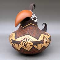 A parrot effigy pot with a feathered crown and decorated with a mountain, forest, deer with heart line and geometric design
 by Anderson Peynetsa of Zuni