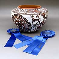 A high shouldered polychrome jar decorated with a two panel rosette, deer with heart line I n his house, rainbird, kiva step, fineline and geometric design. Best of Show and First Place ribbon  from San Diego Museum of Man. First Place ribbon from 2009 Zuni Festival of Arts and Culture
 by Noreen Simplicio of Zuni