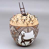 A polychrome jar with a pueblo sculptured top, three panel deer with heart line and geometric design, and on the top, tiny, tiny people, pots, ovens and an attached ladder in the kiva opening
 by Noreen Simplicio of Zuni