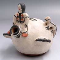 A polychrome canteen with 1 child sitting on the spout, 2 lizard appliques, handles and a plant and geometric design