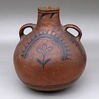 A large black on red round canteen with handles and decorated with a rainbow, cloud, plant and geometric design